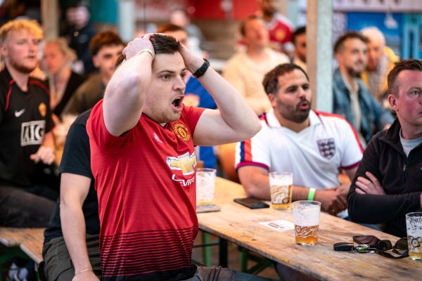 Sport fans watching live sport outside in the beer garden