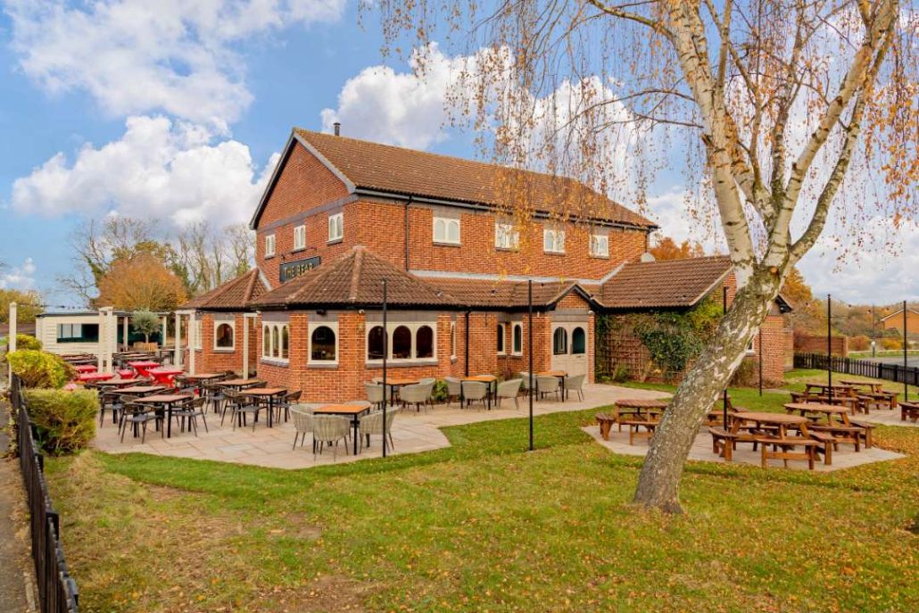 Exterior of the Bear pub rugby - large tree in foreground with outside tables